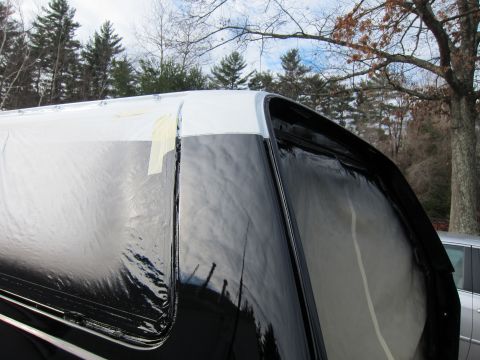 1987 Dodge 1500 - A truck bed cap is being prepped for painting, with plastic sheeting and masking tape applied.