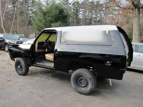 1987 Dodge 1500 - This 1987 Dodge 1500 SUV is undergoing a paint job, with doors open and masking tape visible.