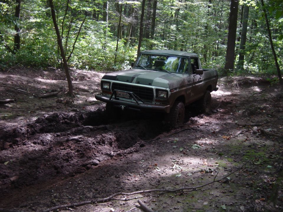 Camouflaged Ford F-Series truck stuck in mud, front view