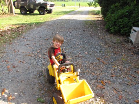 1979 Ford Bronco - Child plays on a toy tractor with a Ford Bronco in the background.