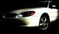 2001 Ford Taurus - A white sedan is shown from the front quarter angle against a dark background.