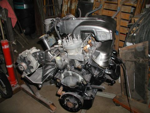 1960 Ford Ranchero - A V8 engine, likely from a Ford, is mounted on an engine stand in a workshop setting.