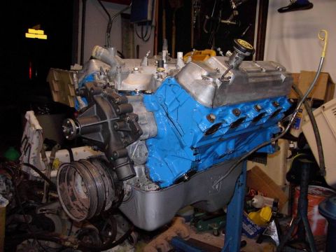 1980 Ford Bronco - Engine assembly with blue block and silver valve covers sits on a stand.