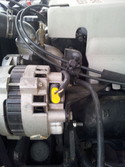 1994 GMC Sierra 3500 - The photo shows a close-up view of an engine bay, focusing on the alternator and associated wiring.