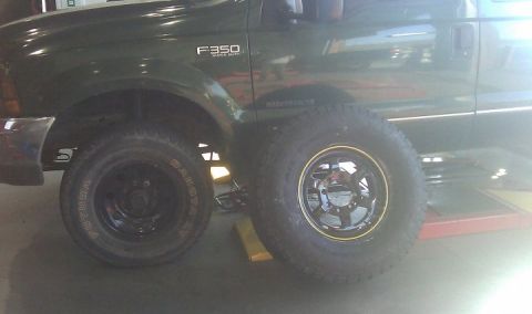 2000 Ford F-350 - Side view of a green 2000 Ford F-350 Super Duty truck, showing the front fender and two tires.