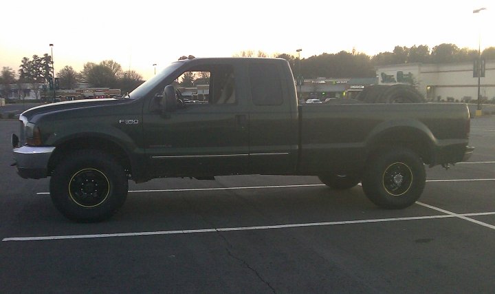 Dark green 2000 Ford F-350 Super Duty pickup truck, side view. F-350 badge visible on fender