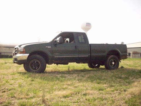 2000 Ford F-350 - A dark green Ford F-350 pickup truck is shown from the side in a grassy field.