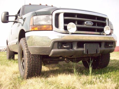 2000 Ford F-350 - This Ford Super Duty truck features a prominent chrome grille and is parked on a grassy field.