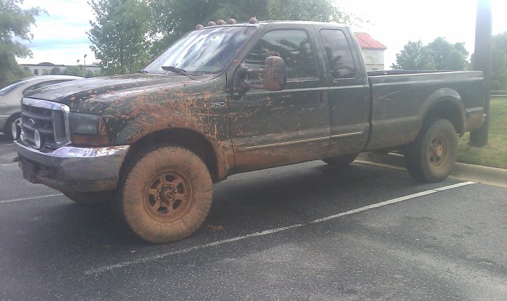 Mud-covered 2000 Ford F-350 pickup truck parked in a lot