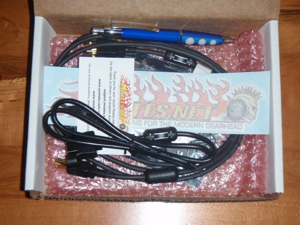 Box with Moates.net parts, cables, and a blue pen