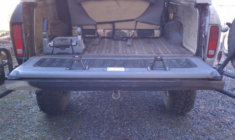 1979 Ford Bronco - The interior of this Ford Bronco shows its cargo bed and rear seating, with the tailgate open.