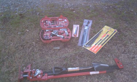 1979 Ford Bronco - Various tools including a toolbox, pry bars, and a hi-lift jack are laid out on the ground.