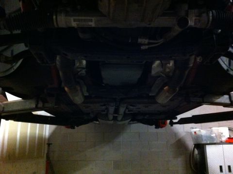 2010 Dodge Challenger - The underside of a car is visible, with various mechanical parts and exhaust systems.