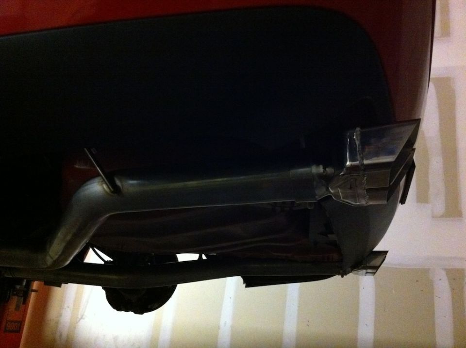 Rear bumper and quad exhaust tips on a red vehicle