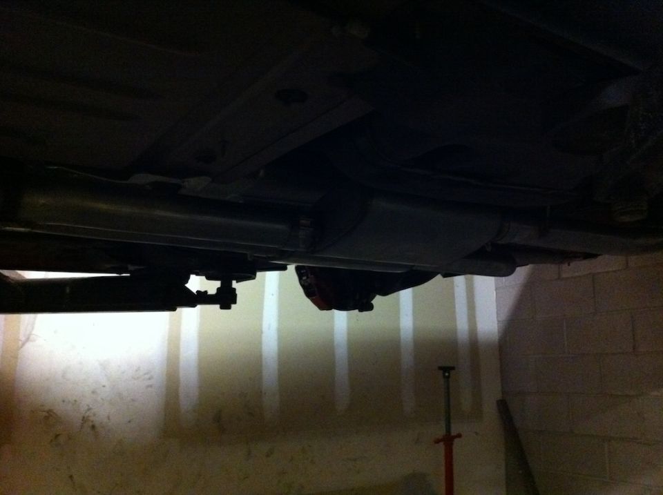 Underside view of a vehicle showing the exhaust pipe and muffler