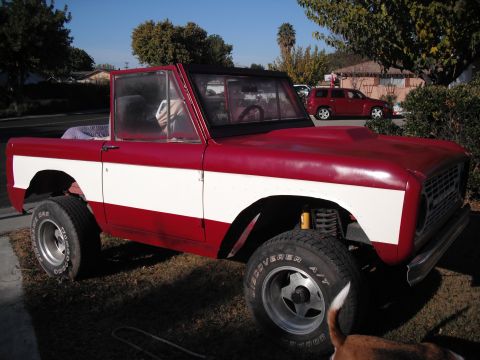 1968 Ford Bronco - This two-tone Ford Bronco is parked in a residential area with a red SUV visible behind it.