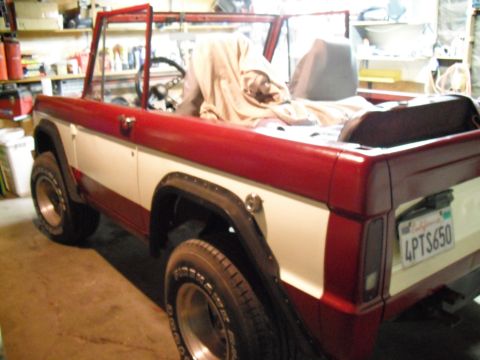 1968 Ford Bronco - This two-tone Ford Bronco is parked inside a garage, with its interior covered by a tarp.