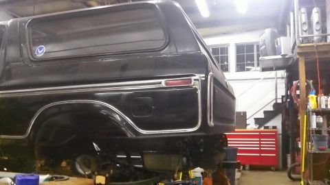 1979 Ford Bronco - This black Ford Bronco is in a garage, possibly undergoing maintenance or modification.