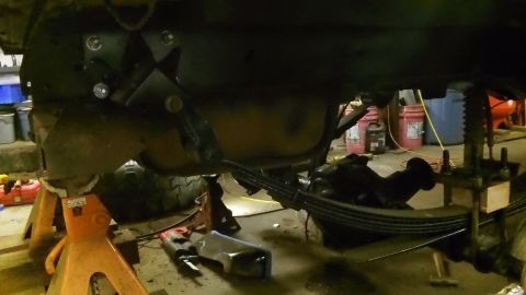 1979 Ford Bronco - Underbody view of a vehicle's suspension and frame components being worked on.