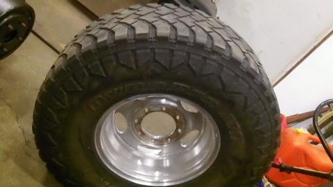 1979 Ford Bronco - A close-up view of a large, aggressive off-road tire mounted on a polished aluminum wheel.