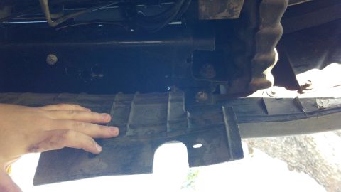 1996 Ford Bronco - A hand touches a plastic undercarriage component of a vehicle, with 'SUPERMOTORS' visible at the bottom.