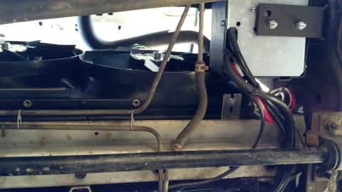 1996 Ford Bronco - Close-up view of a hidden winch installation, showing wiring, hoses, and mounting hardware.