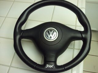 1989 Ford Bronco - A black steering wheel with the Volkswagen logo is shown. The word 'AIRBAG' is visible on the center console.