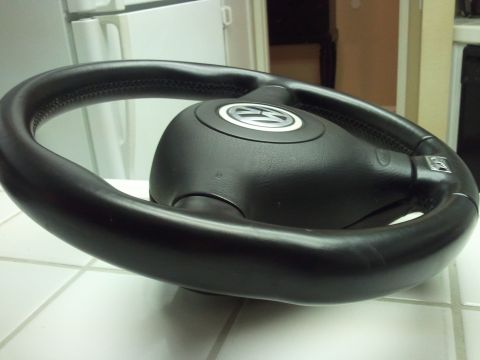 1989 Ford Bronco - A close-up of a Volkswagen steering wheel, likely removed from a vehicle.