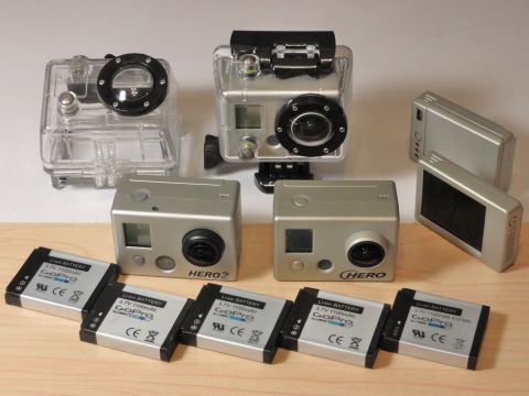 1993 Ford Taurus - A collection of GoPro cameras and spare batteries are laid out on a wooden surface.