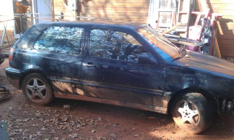 1991 Ford Festiva - This dark blue Volkswagen Golf Mk3 is seen from the side, heavily soiled with mud and resting on blocks.