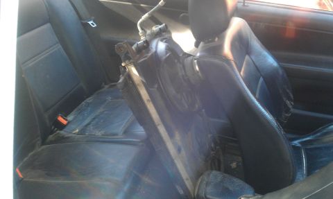 1991 Ford Festiva - A car interior shows a radiator placed across the seats, obscuring the view of the vehicle's model year.