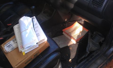 1991 Ford Festiva - Interior of a vehicle showing various documents and a new air filter on the floor.
