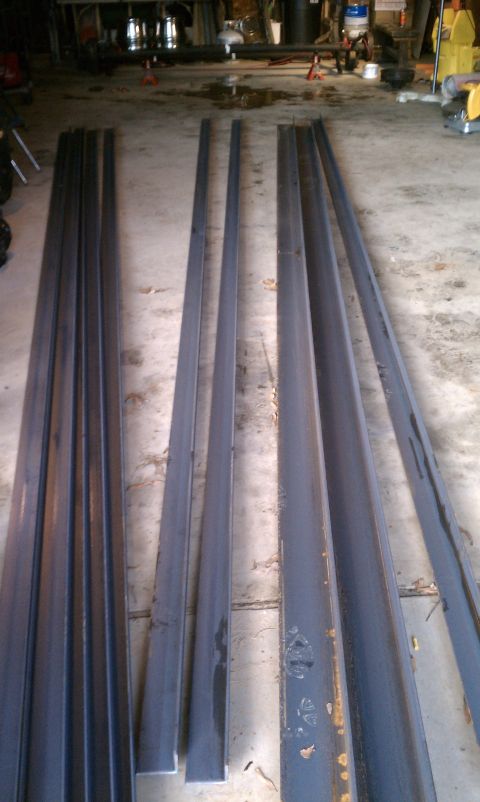 1990 Ford Bronco - Various lengths of steel beams are organized on the floor, possibly for a project.