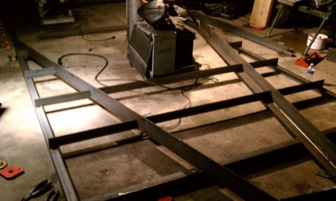 1990 Ford Bronco - Metal frame construction in progress, with welding equipment and tools nearby.