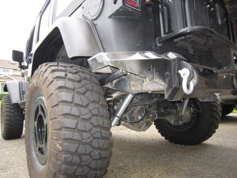 2008 Jeep Wrangler - This Jeep features a custom rear bumper with a prominent tow hook and large off-road tires, suggesting it is modified for terrain.