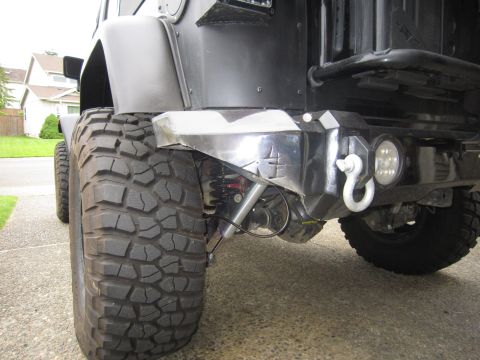 2008 Jeep Wrangler - Close-up of a black Jeep Wrangler's rear bumper and tire, showing off-road modifications.