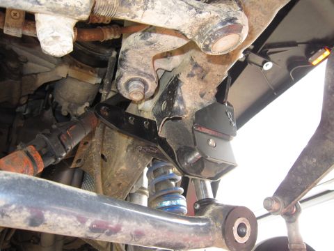 2008 Jeep Wrangler - Close-up view of an aftermarket steering brace installed on a Jeep Wrangler's suspension.