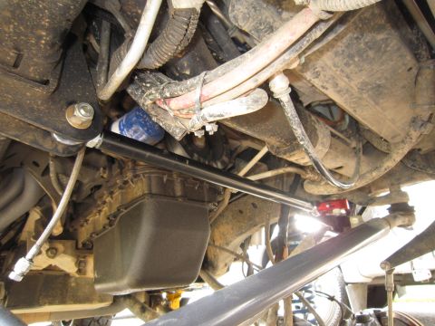 2008 Jeep Wrangler - A close-up view of a steering brace installed on the undercarriage of a vehicle, with various engine parts and hoses visible.