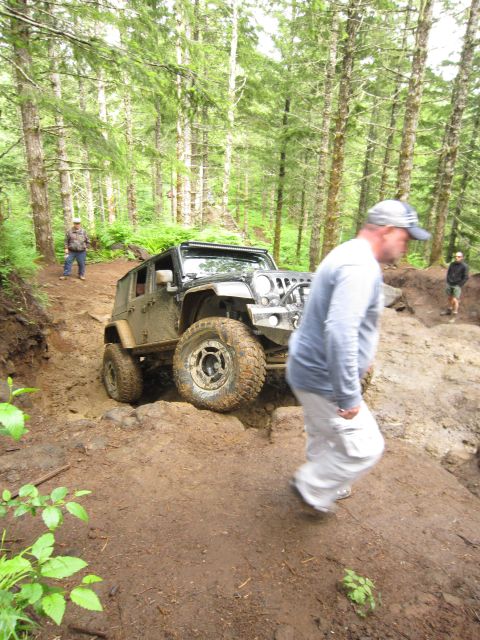 2008 Jeep Wrangler - A Jeep Wrangler tackles a challenging off-road course in a wooded area.