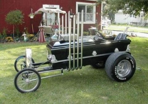 1991 Ford LTD Crown Victoria - A custom-built vehicle resembling a coffin with multiple exhaust pipes sits on a grassy lawn.