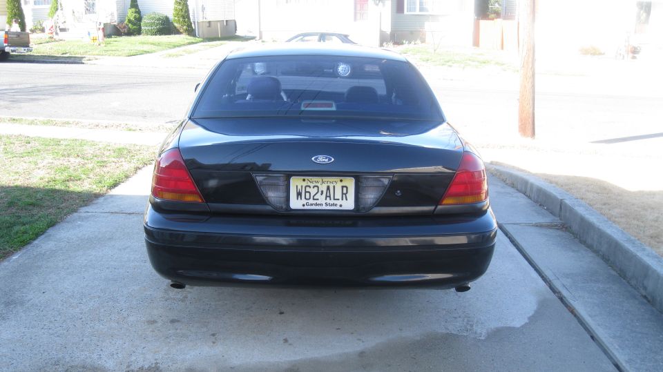 Black Ford Crown Victoria rear view, license plate W62-ALR, parked on concrete