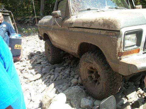 1979 Ford Bronco - Muddy 1978 Ford Bronco tackling a challenging rocky off-road path.
