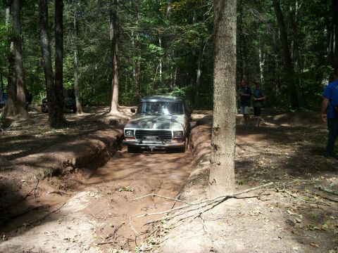 1979 Ford Bronco - This 1979 Ford Bronco navigates a challenging muddy path in a wooded area.