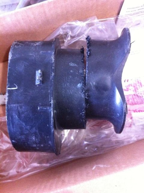 2010 Ford F-150 - A black rubber part is shown inside a cardboard box, partially covered by plastic wrap.