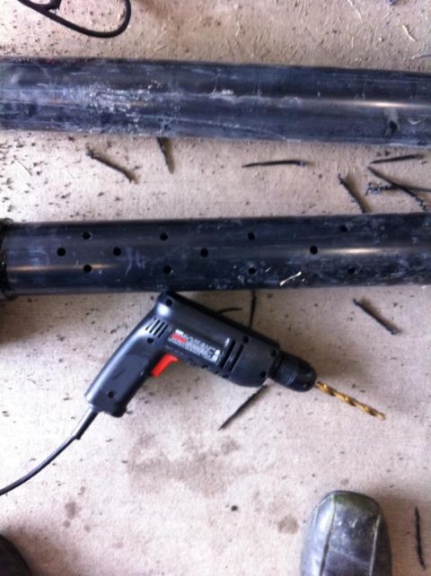 2010 Ford F-150 - A drill and two pipes are on a concrete surface. One pipe has many holes drilled into it.