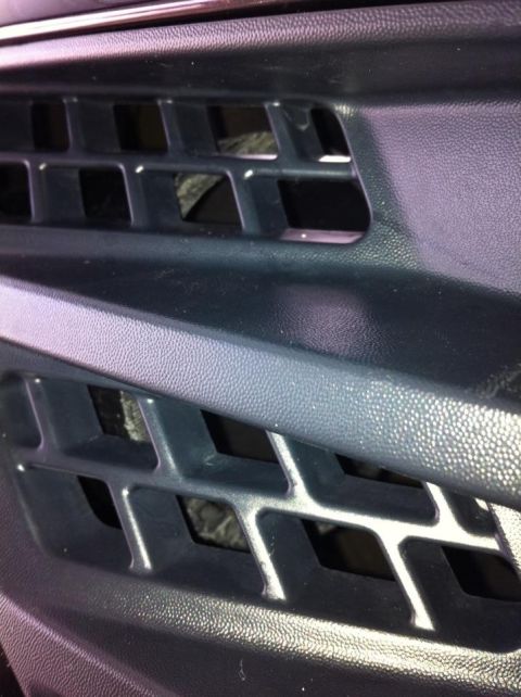 2010 Ford F-150 - Close-up view of a vehicle's black plastic grille, showing its textured surface and geometric openings.