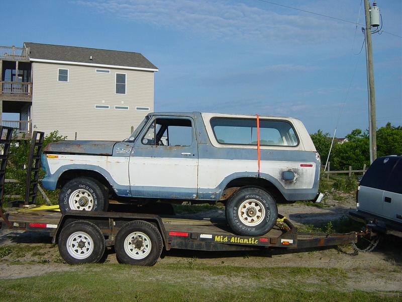 Side view of a blue and white 1979 Ford Bronco on a trailer