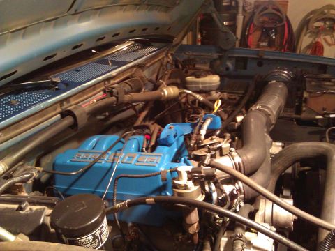 1992 Ford F-150 - The engine bay of a vehicle, showing the motor and associated parts.