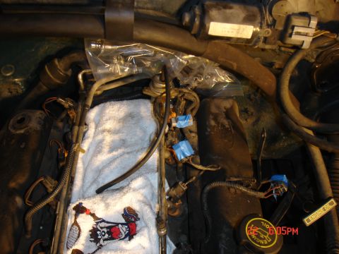 1995 Ford Bronco - Close-up view of engine bay components, including fuel injectors and wiring, with a towel and patch visible.
