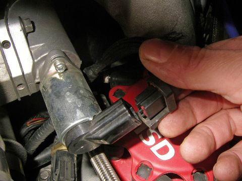 1990 Ford Bronco - A hand disconnects a throttle position sensor connector from a red component labeled 'ESD'.